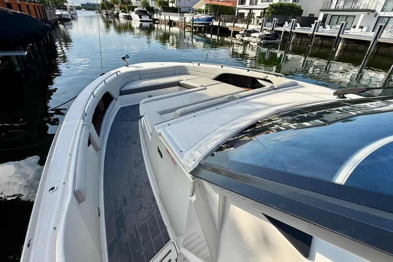 Slide: The Image of 2022 Sea Ray Sundancer 370 Outboard docked in a serene waterfront setting. - 27