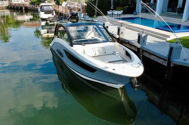 Slide: The Image of 2022 Sea Ray Sundancer 370 Outboard docked by a luxurious waterfront pool. - 3