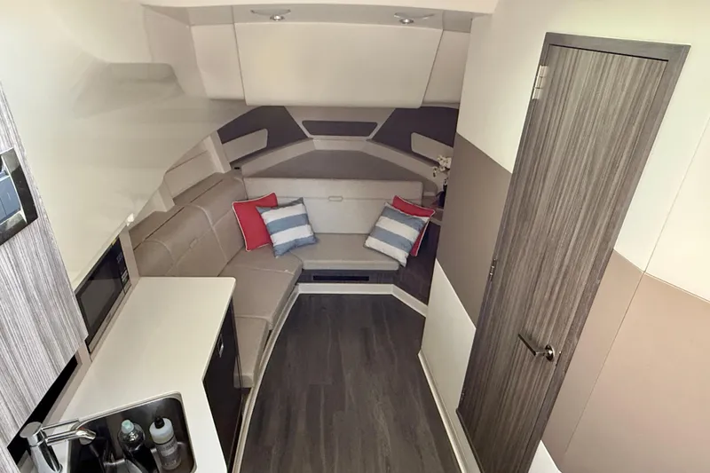 Slide: The Image of Interior of 2022 Sea Ray Sundancer 370 Outboard, featuring modern seating and compact kitchenette. - 31