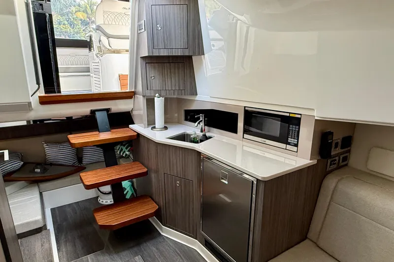 Slide: The Image of 2022 Sea Ray Sundancer 370 Outboard interior with kitchenette, stairs, and seating area. - 36