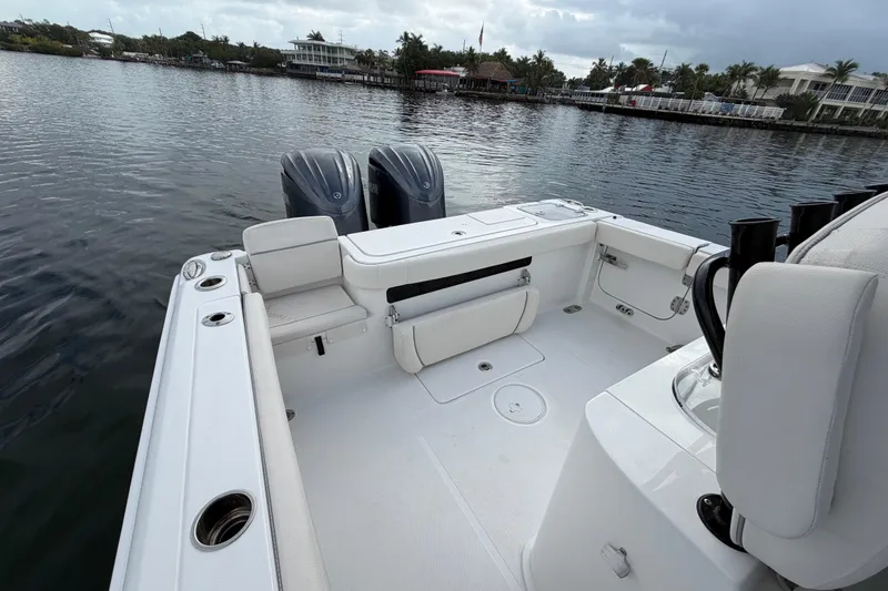 Slide: The Image of 2023 Sea Hunt Gamefish 27 boat with forward seating, docked on calm water. - 11