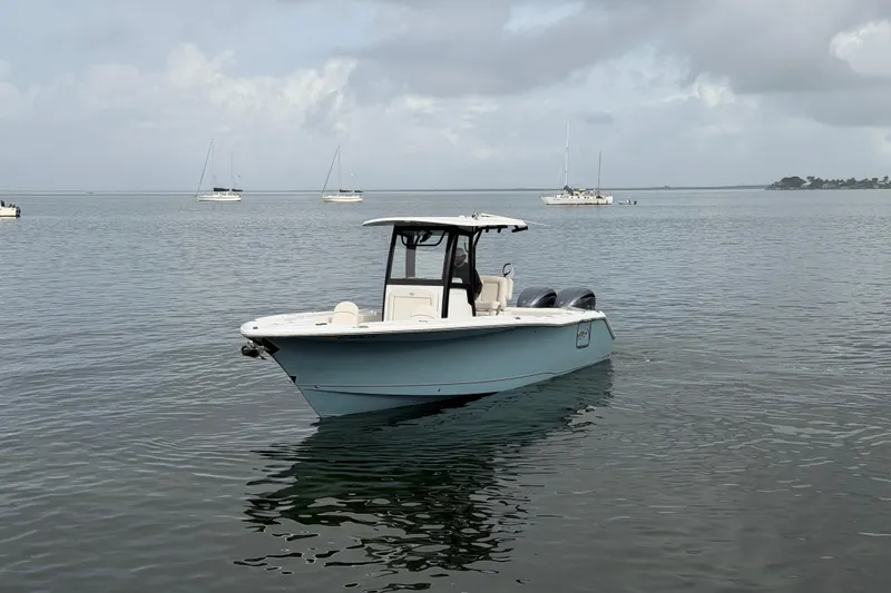 Slide: The Image of 2023 Sea Hunt Gamefish 27 boat on calm water with distant sailboats. - 5