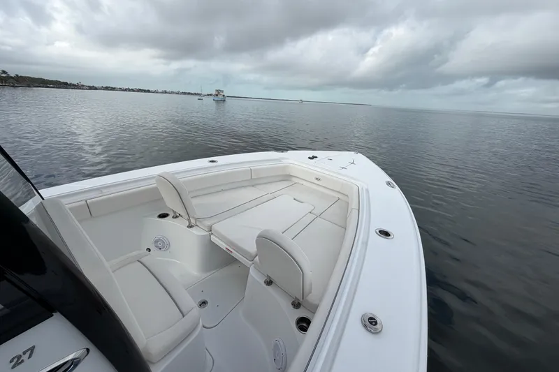 Slide: The Image of 2023 Sea Hunt Gamefish 27 Forward Seating boat on calm water under cloudy sky. - 9