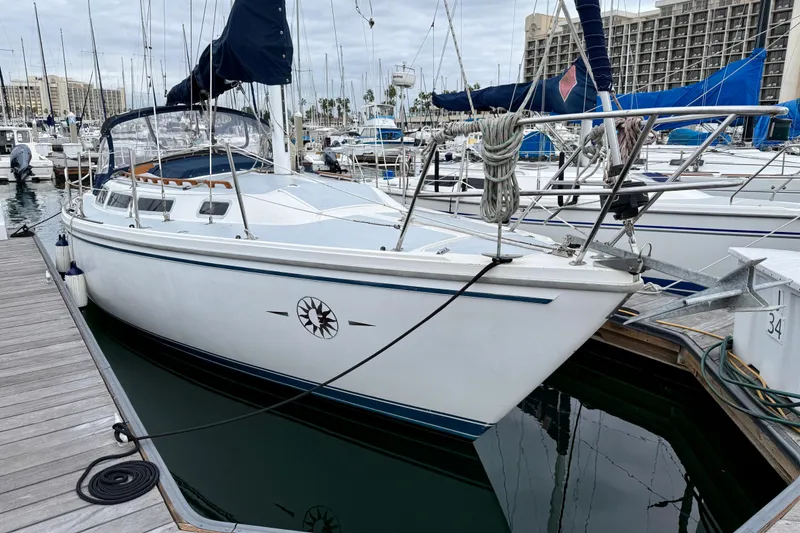 The Image of 1982 Catalina 30 sailboat docked at marina, overcast sky, nautical setting. - 0