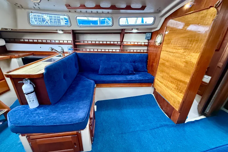 Slide: The Image of Interior of 1982 Catalina 30 sailboat with blue seating and wooden accents. - 18