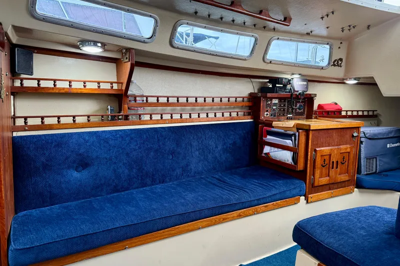 Slide: The Image of Interior of 1982 Catalina 30 sailboat with blue seating and wooden cabinetry. - 22