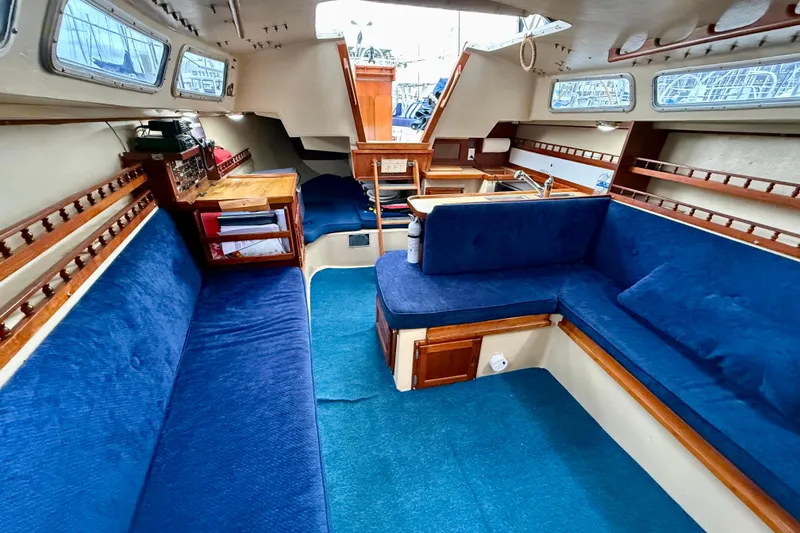 Slide: The Image of Interior of 1982 Catalina 30 sailboat with blue upholstery and wooden accents. - 23