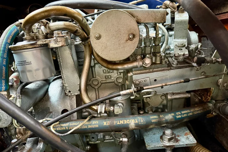 Slide: The Image of 1982 Catalina 30 engine close-up, showcasing mechanical components and hoses. - 34