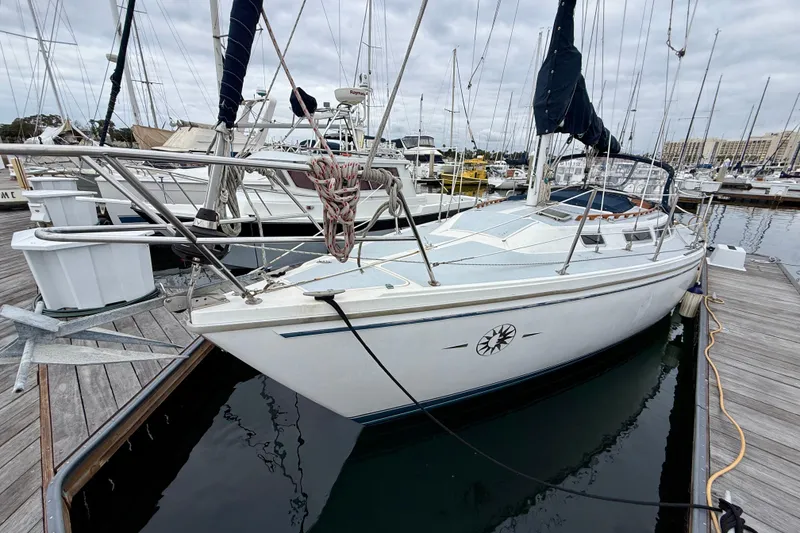 Slide: The Image of 1982 Catalina 30 sailboat docked at marina, overcast sky, nautical setting. - 8