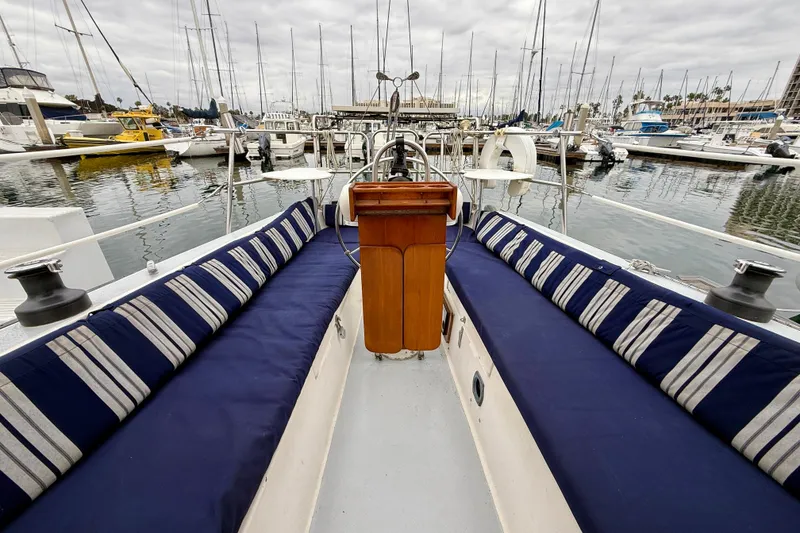 Slide: The Image of 1982 Catalina 30 sailboat interior with blue-striped seating, docked in a marina. - 9