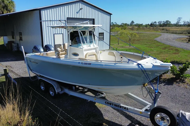 Slide: The Image of 2020 Sailfish 242 CC boat on trailer near metal building, sunny day. - 21