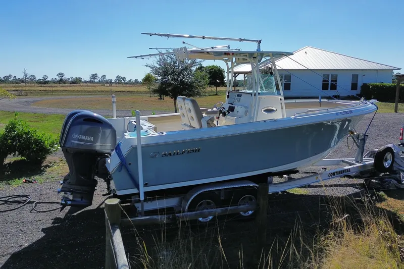 Slide: The Image of 2020 Sailfish 242 CC boat on trailer with Yamaha engine, parked outdoors. - 23