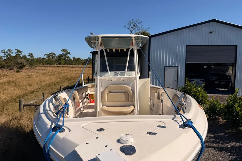 Slide: The Image of 2020 Sailfish 242 CC boat docked near a metal building in a rural setting. - 28