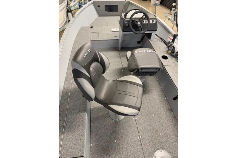 Slide: The Image of 2026 Lund 1600 Fury SS boat interior with steering wheel and cushioned seats. - 10