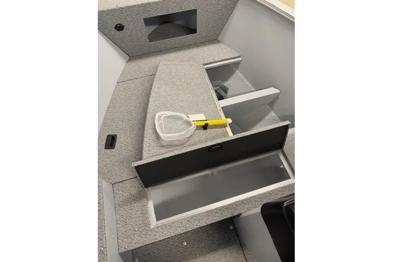 Slide: The Image of 2026 Lund 1600 Fury SS boat interior with storage compartments and fishing net. - 15