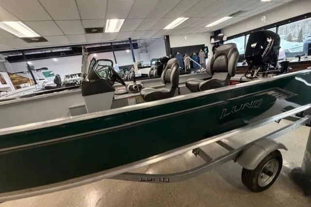 Slide: The Image of 2026 Lund 1600 Fury SS boat displayed indoors, featuring sleek design and comfortable seating. - 2
