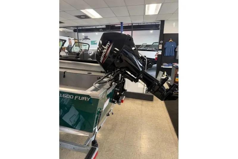 Slide: The Image of 2026 Lund 1600 Fury SS boat with Mercury outboard motor in showroom. - 5