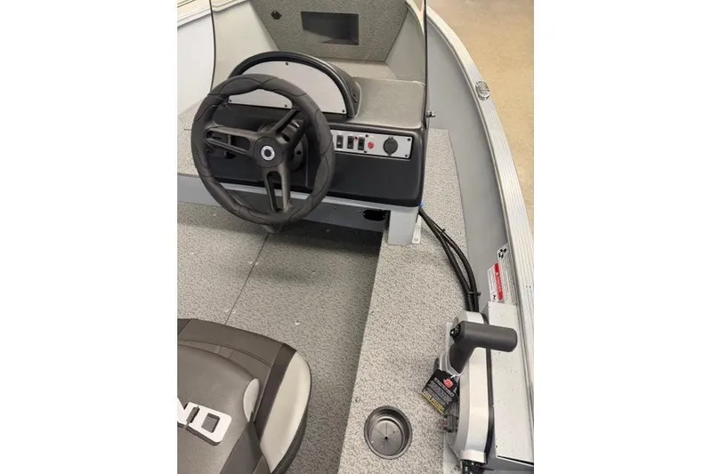 Slide: The Image of 2026 Lund 1600 Fury SS boat interior with steering wheel and control panel. - 8