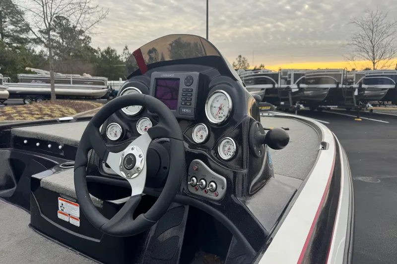 Slide: The Image of 2013 Nitro Z-6 boat dashboard with steering wheel and gauges at sunset. - 1