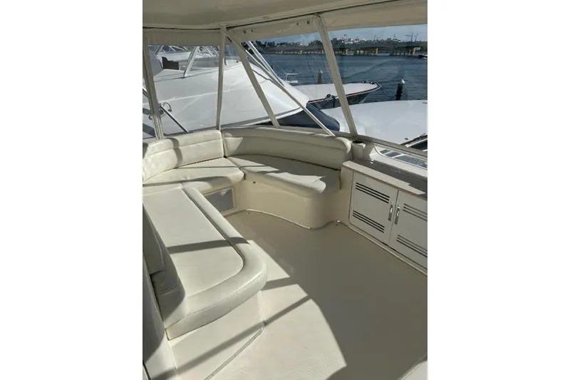 Slide: The Image of 2004 Silverton 48 Convertible yacht helm with white captain chairs at marina. - 12