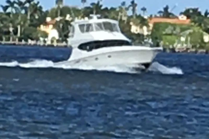 Slide: The Image of 2004 Silverton 48 Convertible yacht cruising on a scenic waterway. - 2