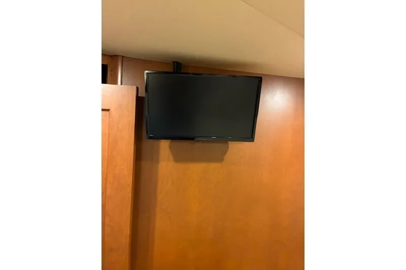 Slide: The Image of Wall-mounted TV inside 2004 Silverton 48 Convertible yacht interior. - 61