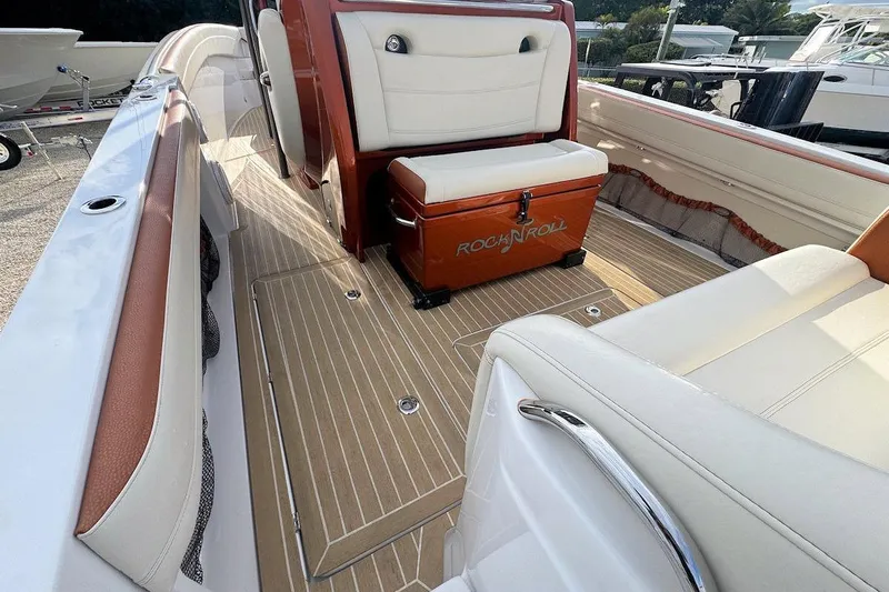 Slide: The Image of 2016 Nor-Tech 340 Sport Center Console interior with cushioned seating and wooden flooring. - 12