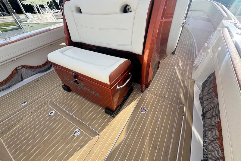 Slide: The Image of 2016 Nor-Tech 340 Sport Center Console interior with cushioned seating and teak flooring. - 13