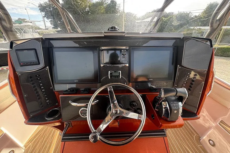 Slide: The Image of 2016 Nor-Tech 340 Sport Center Console dashboard with dual screens and steering wheel. - 15