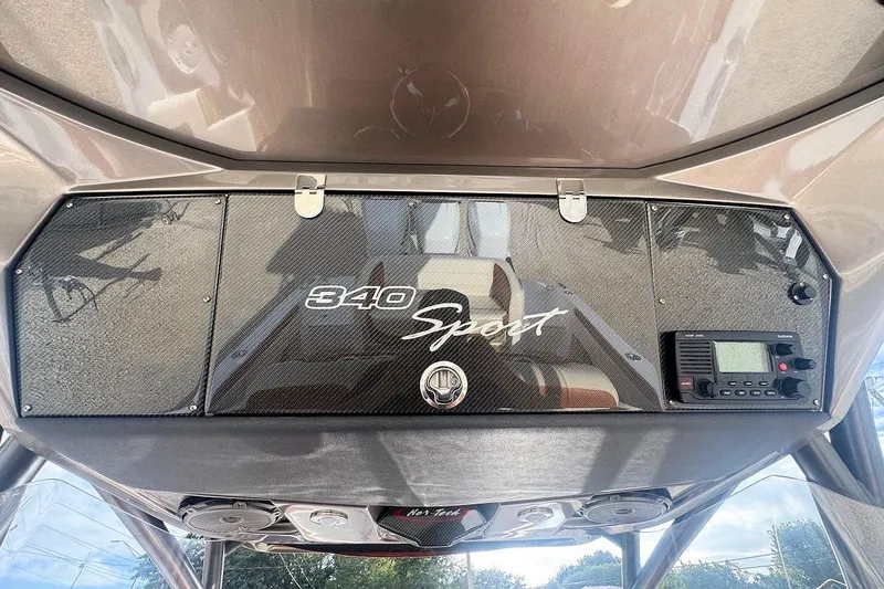 Slide: The Image of 2016 Nor-Tech 340 Sport Center Console dashboard with carbon fiber finish and radio controls. - 16