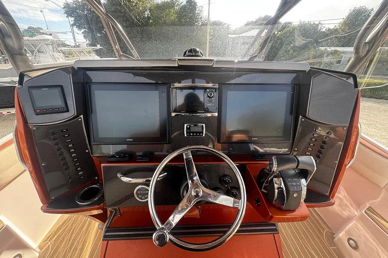 Slide: The Image of 2016 Nor-Tech 340 Sport Center Console dashboard with steering wheel and navigation screens. - 17