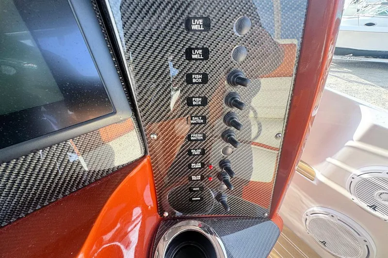 Slide: The Image of Control panel of a 2016 Nor-Tech 340 Sport Center Console boat with carbon fiber finish. - 19