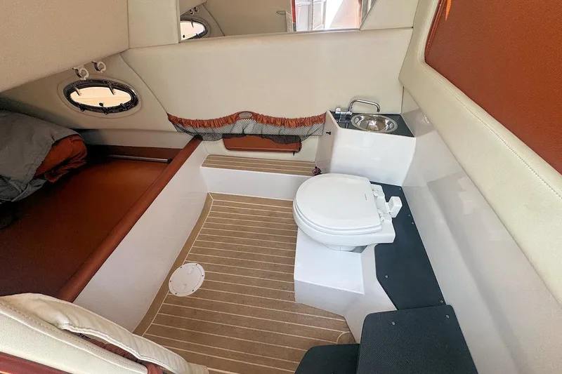 Slide: The Image of 2016 Nor-Tech 340 Sport Center Console cabin with toilet and sink, featuring wood-patterned flooring. - 21