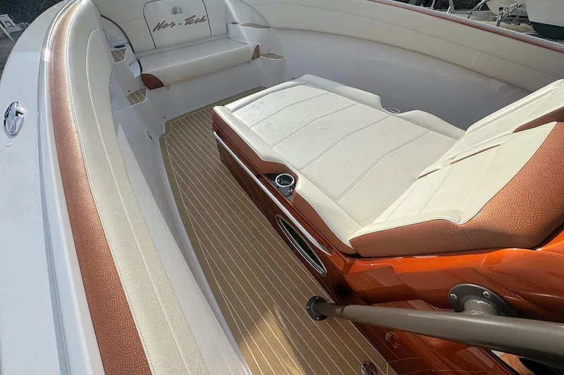 Slide: The Image of 2016 Nor-Tech 340 Sport Center Console interior with cushioned seating and wood-patterned flooring. - 24