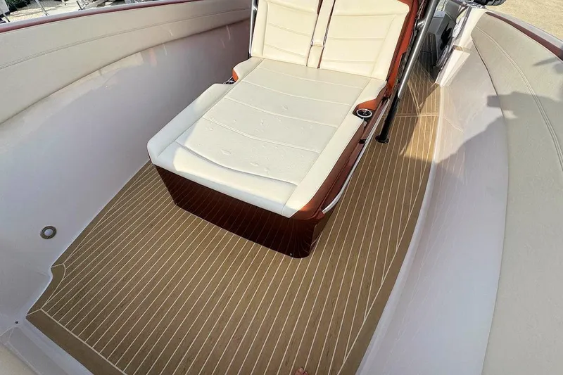 Slide: The Image of 2016 Nor-Tech 340 Sport Center Console interior with cushioned seating and wood-patterned flooring. - 25