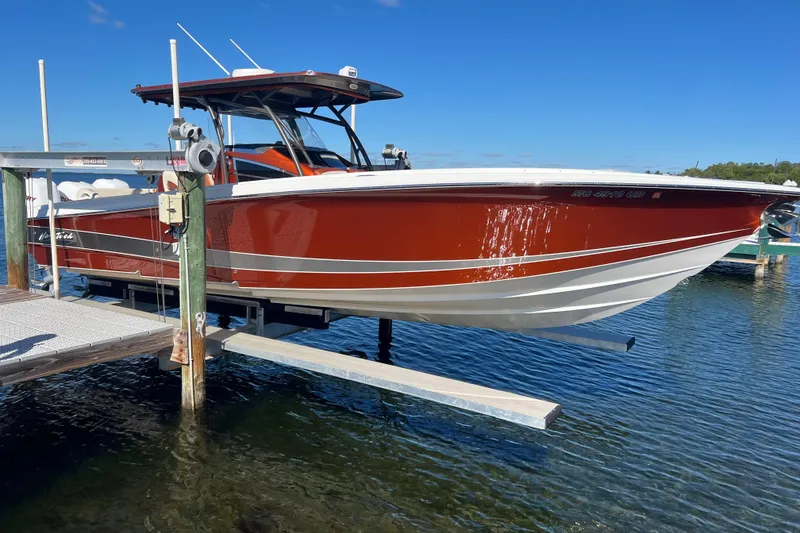 Slide: The Image of 2016 Nor-Tech 340 Sport Center Console boat on lift, docked by clear water. - 29