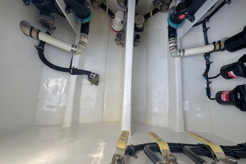 Slide: The Image of Engine compartment of a 2016 Nor-Tech 340 Sport Center Console boat, showing hoses and fittings. - 9