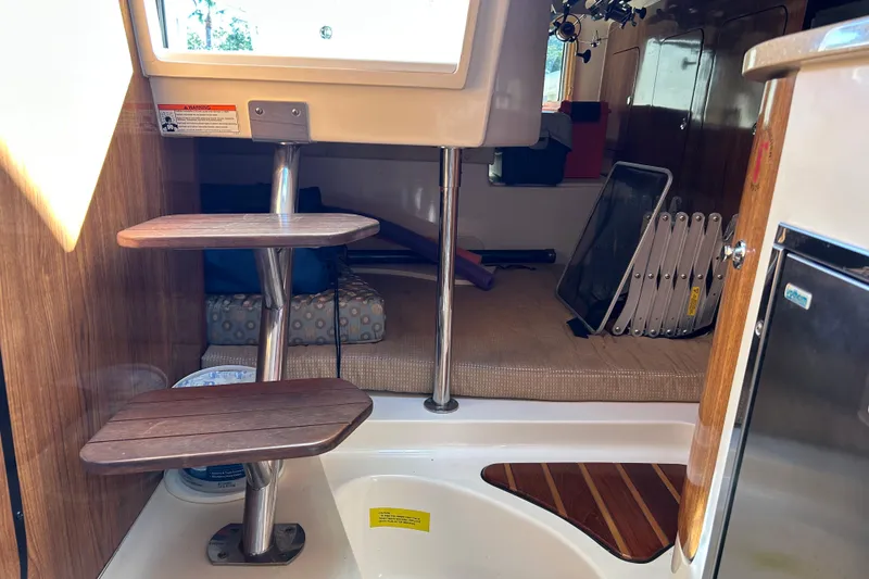 Slide: The Image of Interior of 2008 Pursuit OS 315 Offshore boat with wooden steps and cozy seating area. - 19