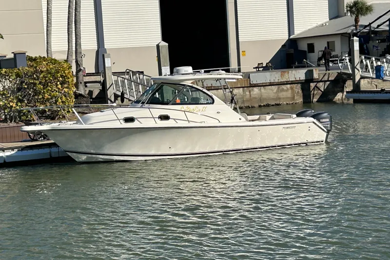 Slide: The Image of 2008 Pursuit OS 315 Offshore boat docked at marina with Yamaha engines. - 2