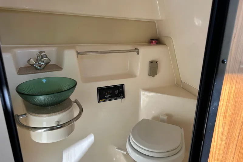Slide: The Image of 2008 Pursuit OS 315 Offshore boat bathroom with glass sink and toilet. - 21