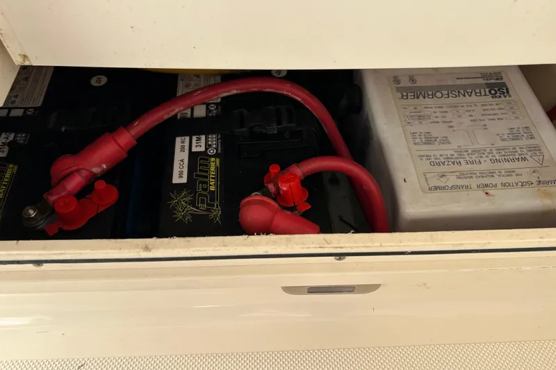 Slide: The Image of Battery compartment of a 2008 Pursuit OS 315 Offshore boat with red cables. - 24