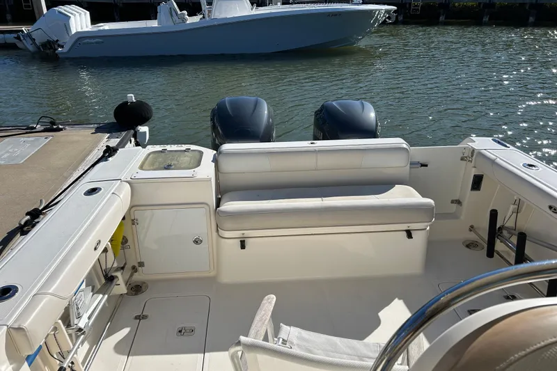 Slide: The Image of 2008 Pursuit OS 315 Offshore boat interior with dual engines, docked in a marina. - 4