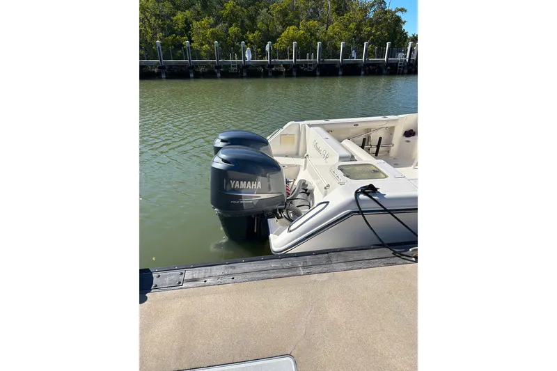 Slide: The Image of 2008 Pursuit OS 315 Offshore boat with Yamaha outboard engines docked by the water. - 7