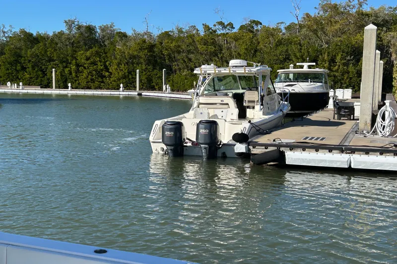 Slide: The Image of 2008 Pursuit OS 315 Offshore boat docked at marina with twin engines. - 9