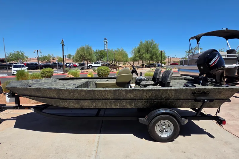 The Image of 2026 Tracker Grizzly 1754 SC boat on trailer, parked outdoors under clear blue sky. - 0