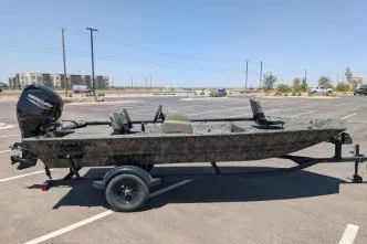 The Image of 2026 Tracker Grizzly 1756 T Marsh boat on trailer in sunny parking lot. - 0