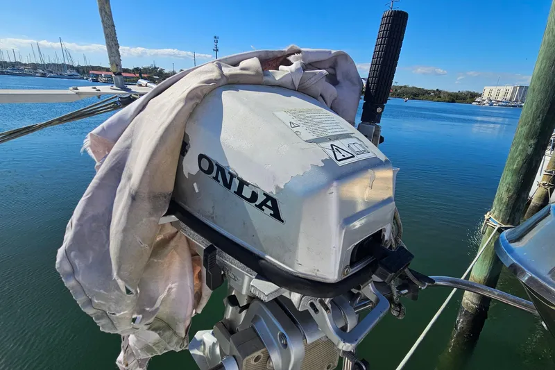 Slide: The Image of Outboard motor on a boat docked at a marina, covered with a cloth. - 11