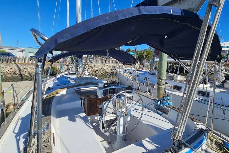 Slide: The Image of 1989 ENDEAVOR 42 sailboat with blue canopy, docked at marina. - 13