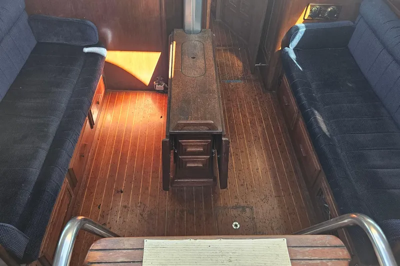 Slide: The Image of Interior of 1989 ENDEAVOR 42 sailboat with wooden flooring and blue cushioned seating. - 27