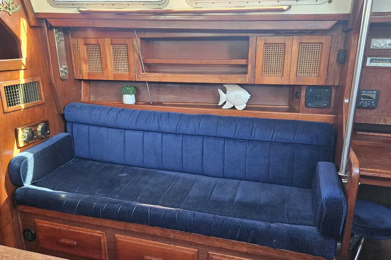 Slide: The Image of Interior of 1989 ENDEAVOR 42 sailboat with blue cushioned seating and wooden cabinetry. - 30